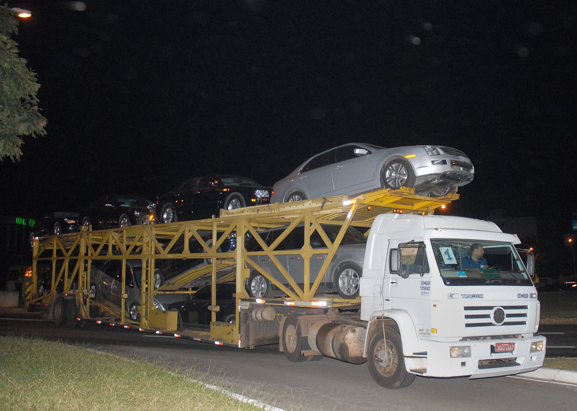 Caminhão-cegonha transportando automóveis novos em estrada brasileira