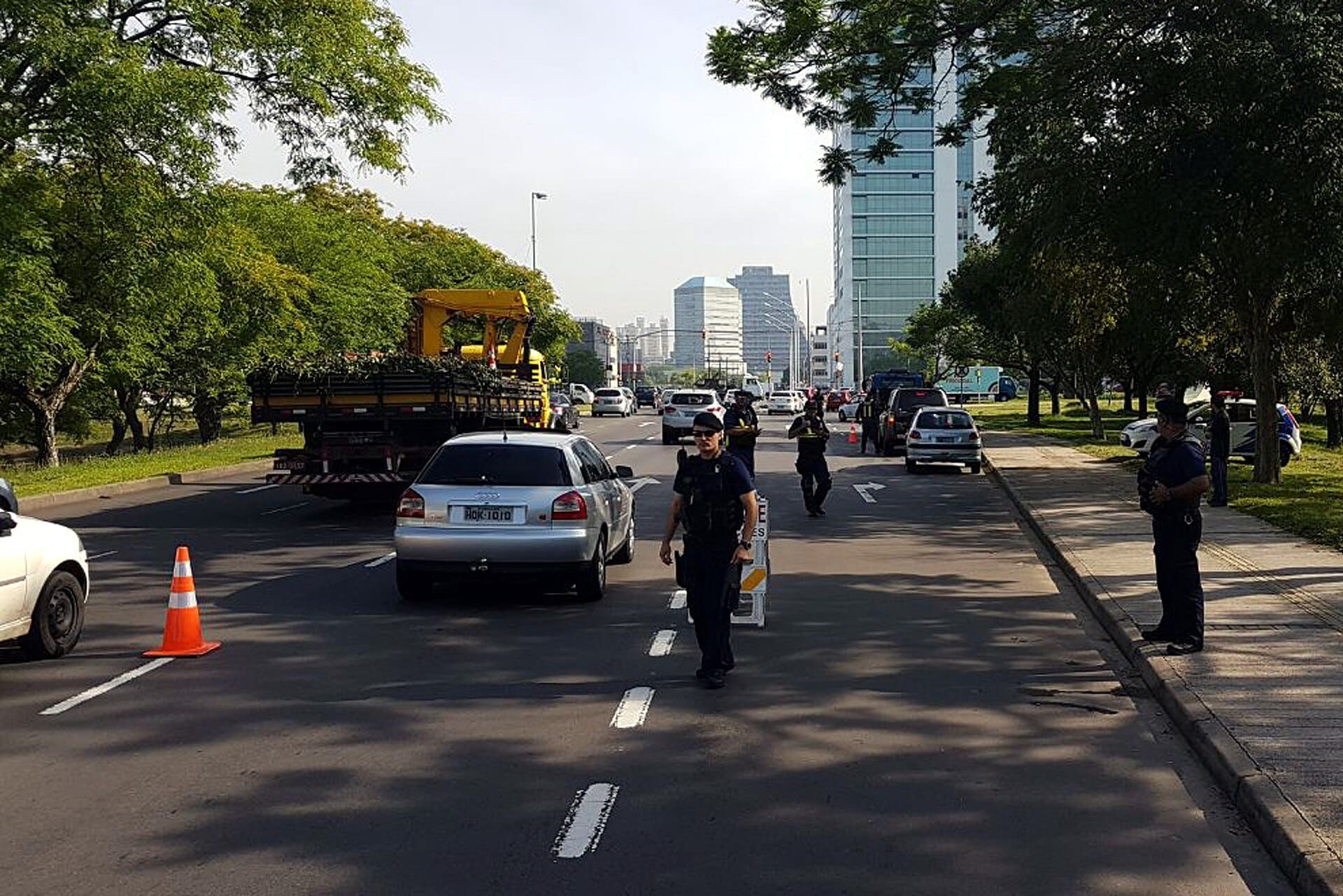 Operação de fiscalização de trânsito com agentes e guincho em avenida