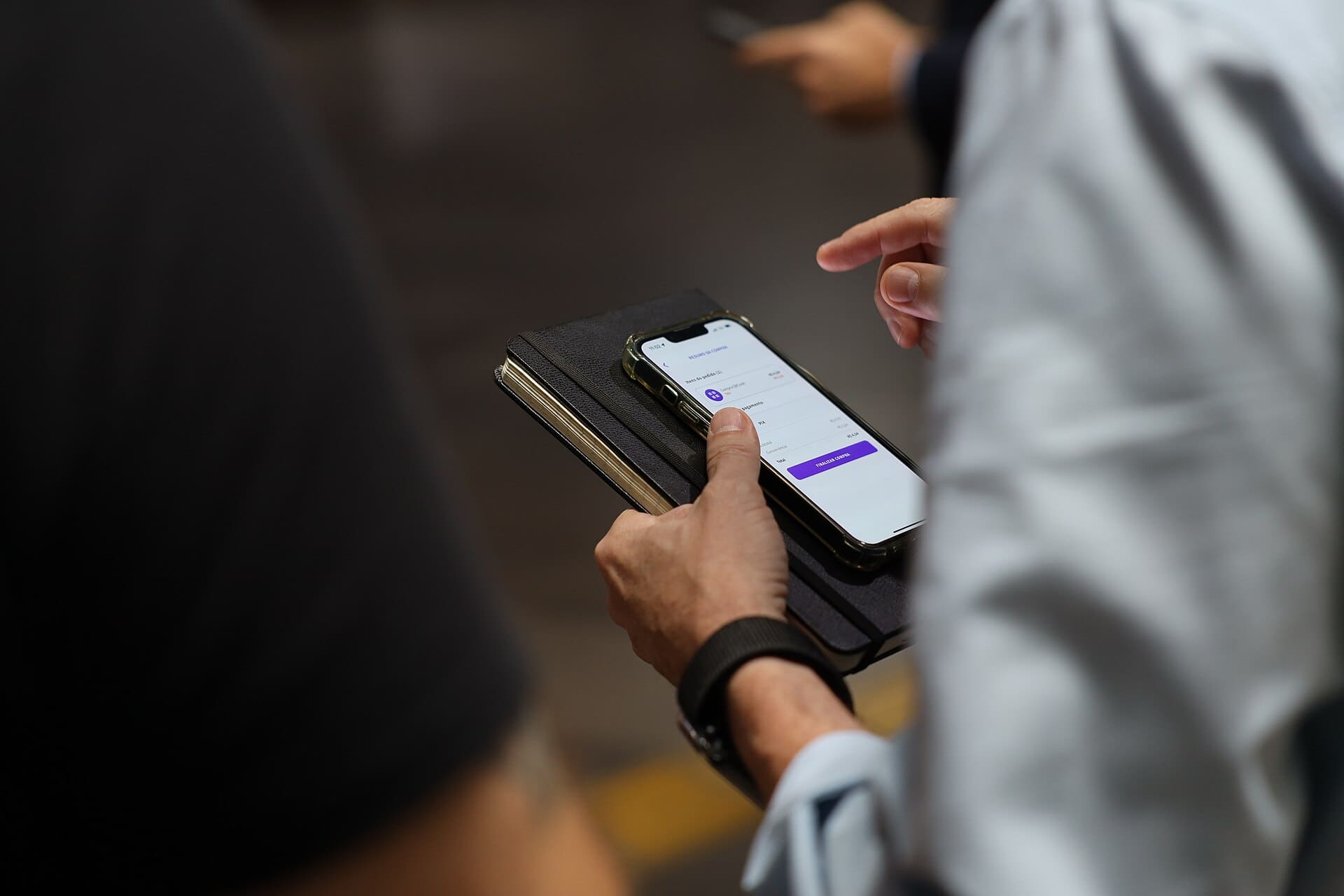 Mãos segurando celular durante validação de pagamento digital