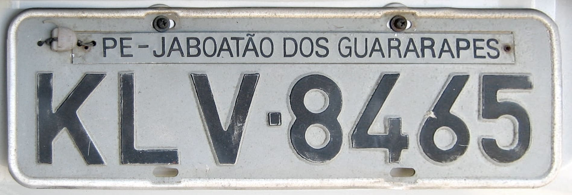 Placa de veículo brasileiro em detalhe, com identificação do município de registro