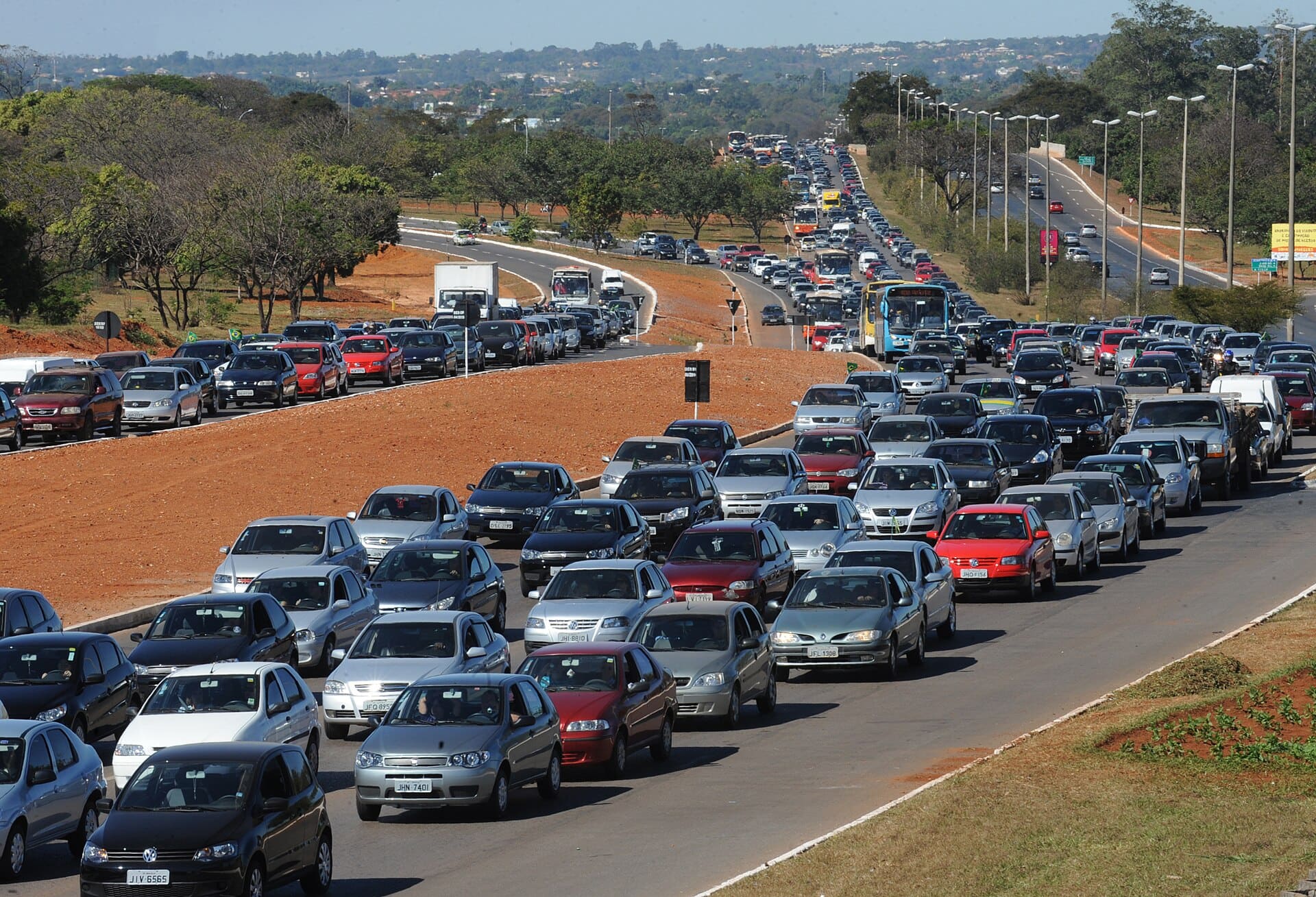 Fluxo intenso de carros em avenida brasileira, representando a frota de veículos em circulação