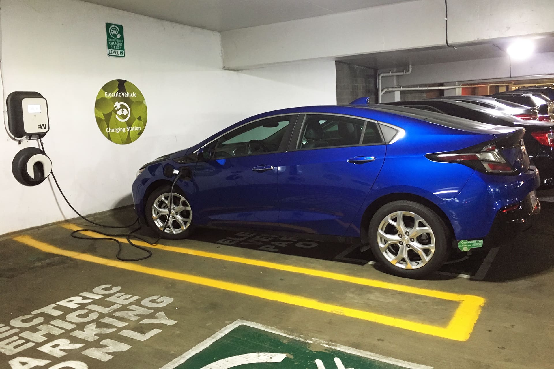 Automóvel híbrido e elétrico em ponto de recarga com foco em eficiência energética